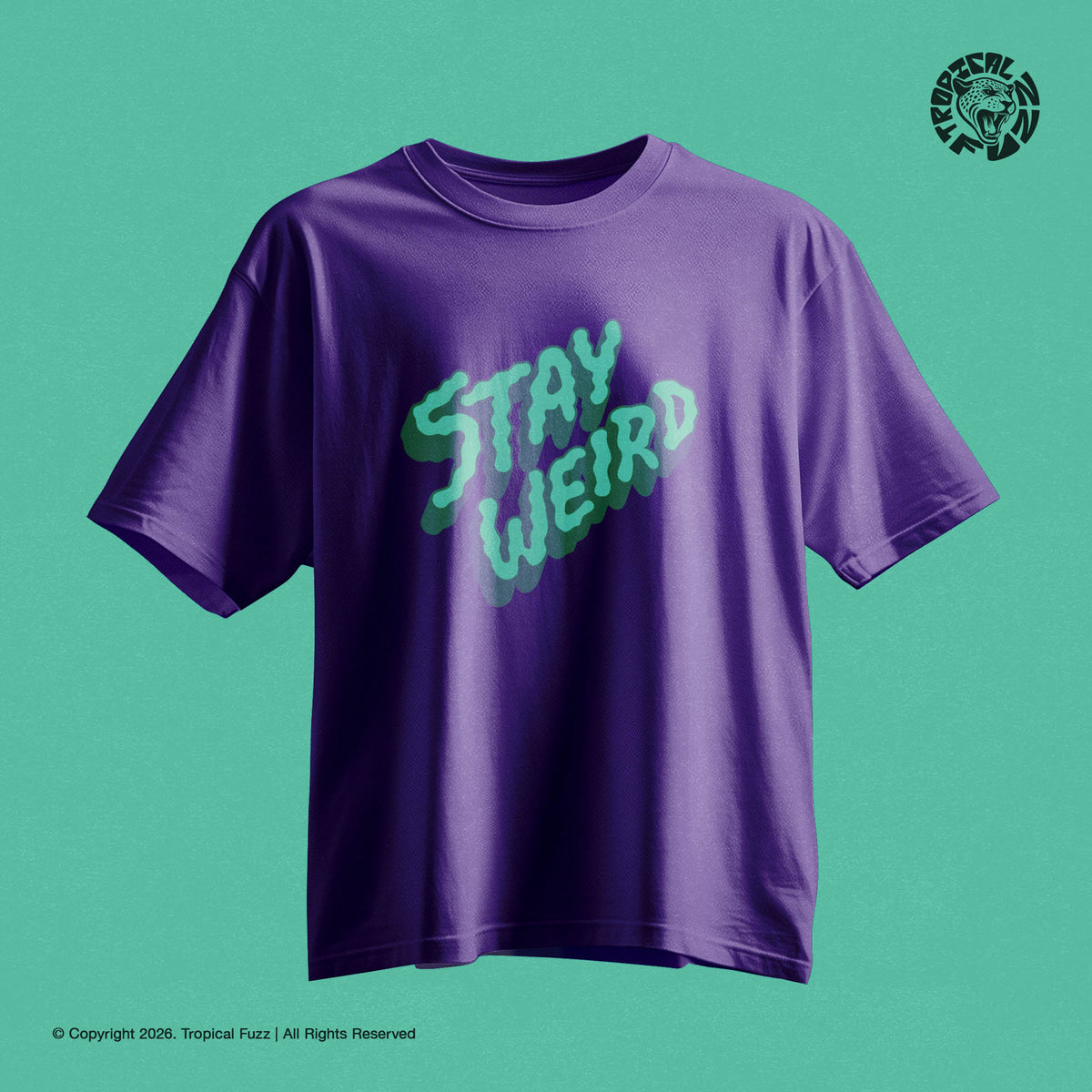 Purple t-shirt with 'Stay Weird' in green on a teal background