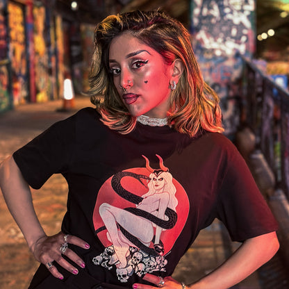 Person wearing a black t-shirt with a graphic design in a colorful, urban setting.