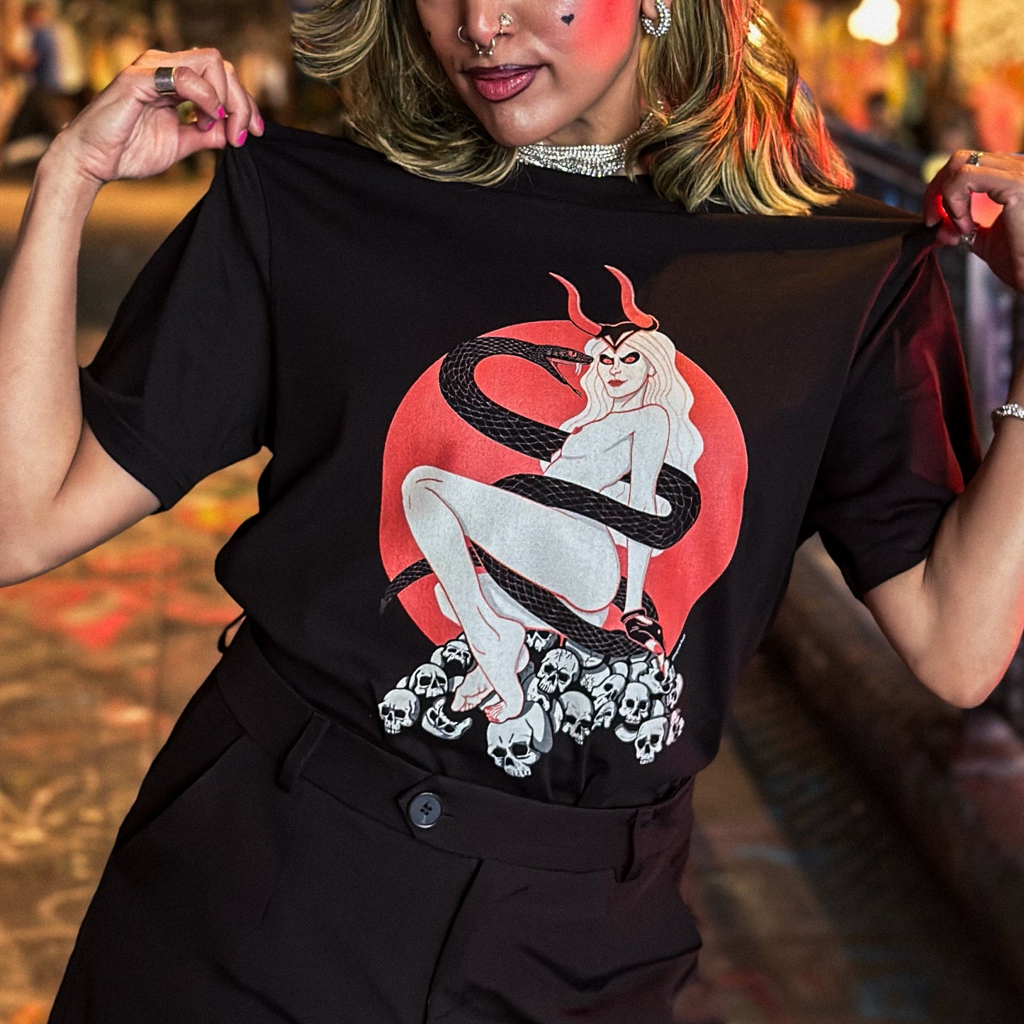 Woman wearing a black t-shirt with a graphic design in a vibrant indoor setting