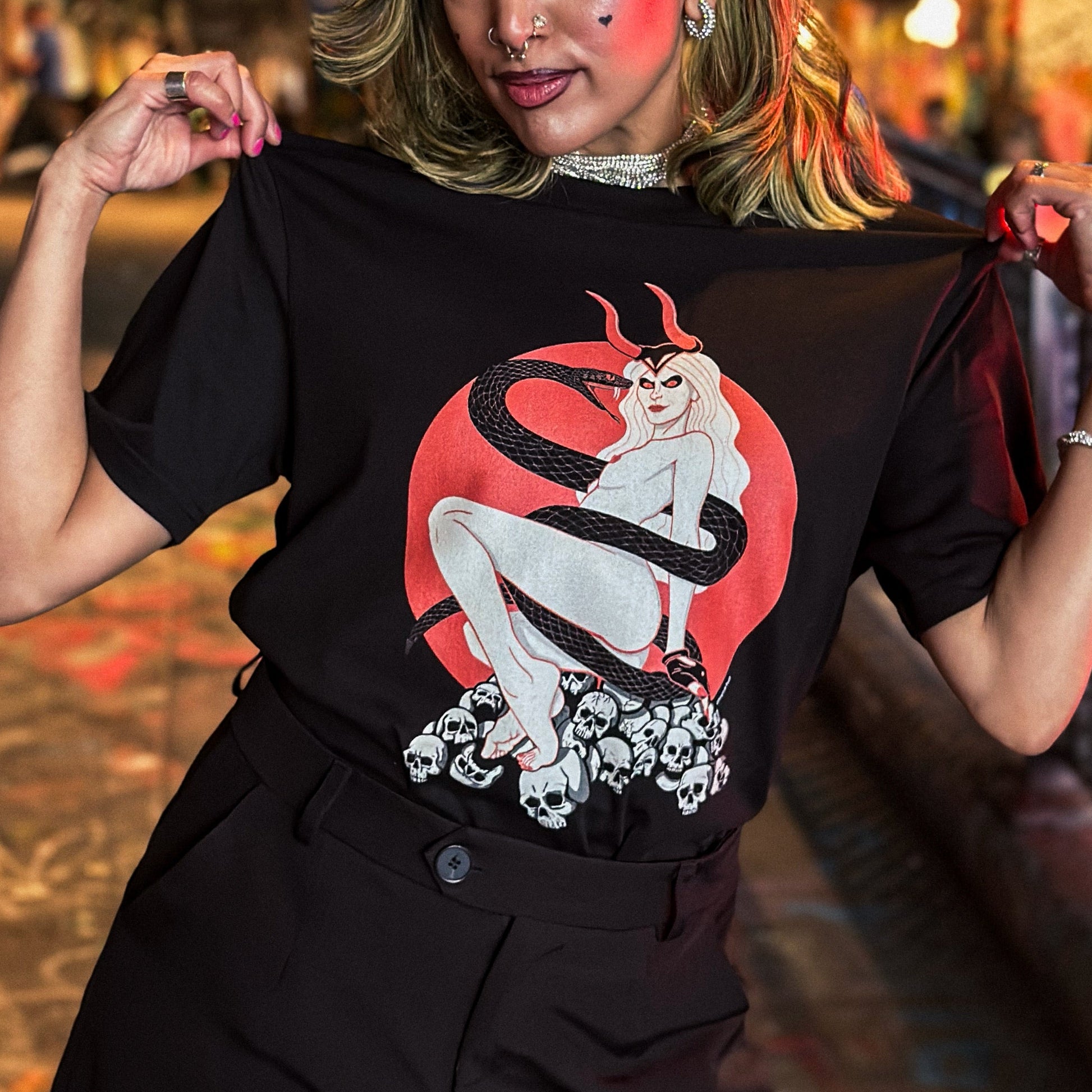Woman wearing a black t-shirt with a graphic design in a vibrant indoor setting