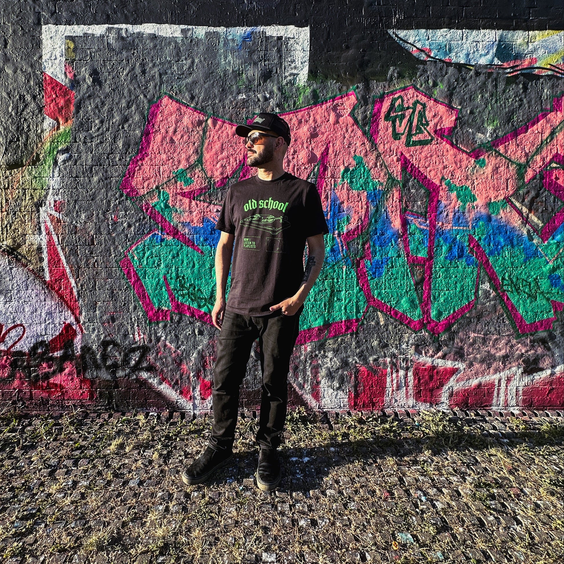Person standing in front of a colorful graffiti wall