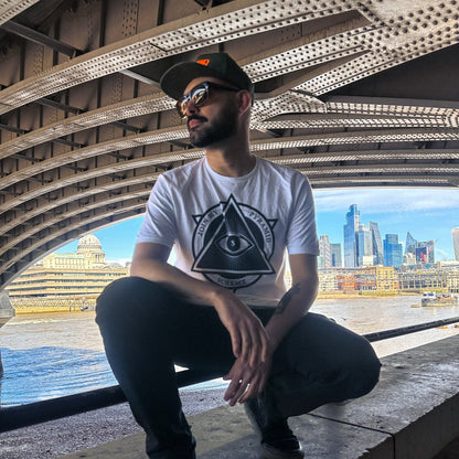 Man sitting on a ledge with a cityscape in the background