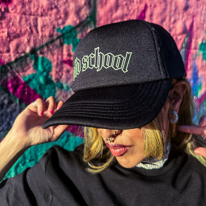 Person wearing a black cap with 'Old School' text against a colorful abstract background
